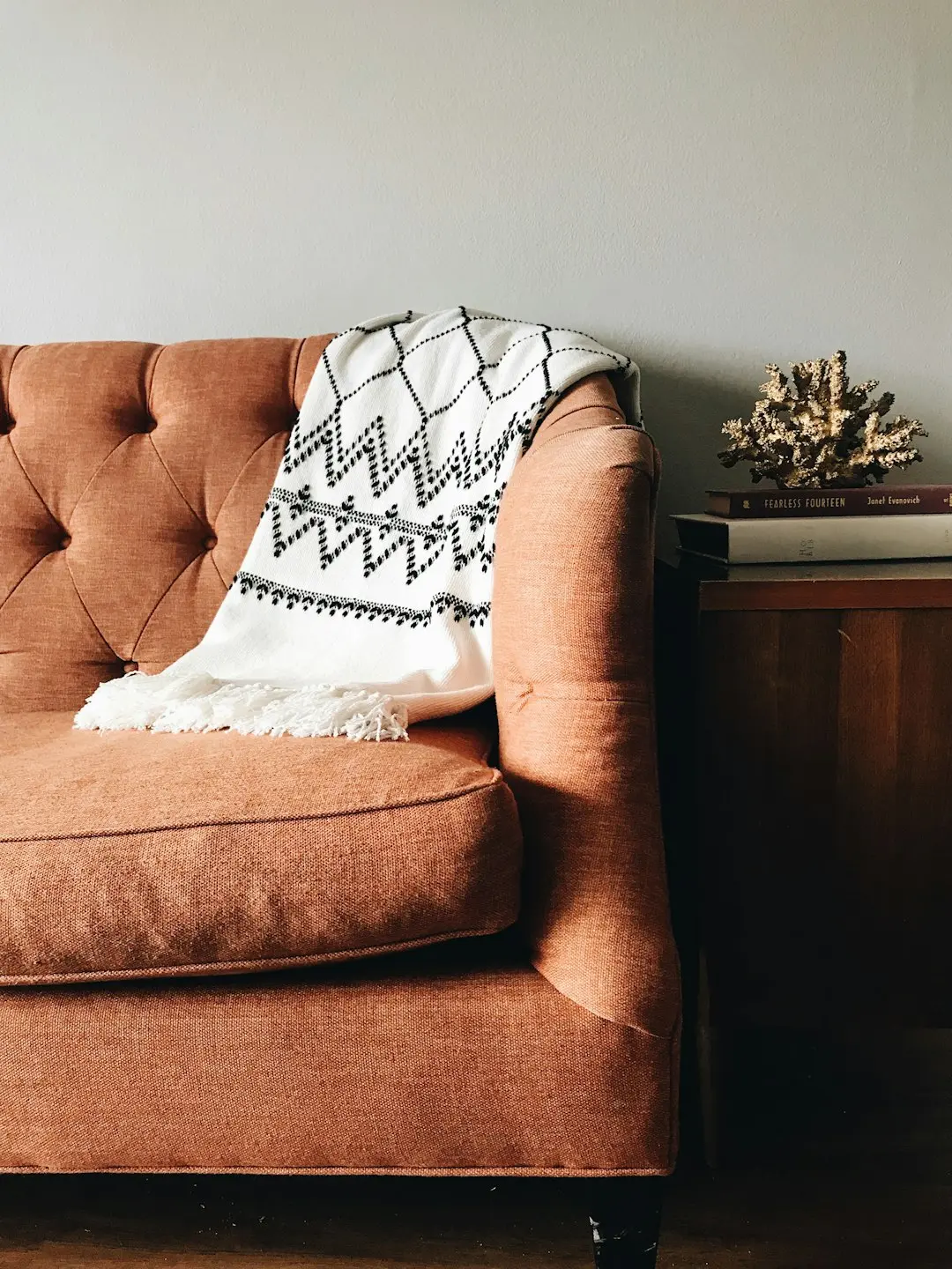 Warm tufted couch with throw blanket in a cozy living space